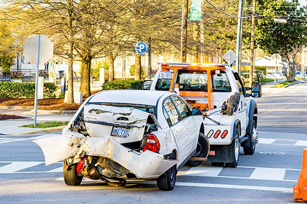 A totaled car being towed to the salvage yard.