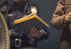 Police officer holding an envelope containing the accident report.